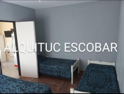 una habitación con 2 camas y un cartel que diga acupuntura Escobar en ALQUITUC ESCOBAR II en Belén de Escobar
