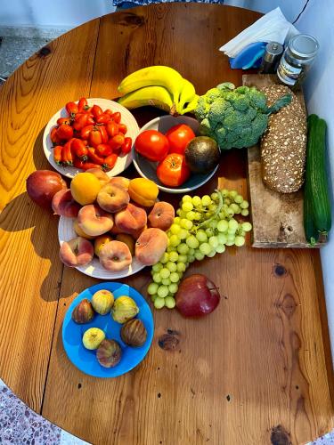 a table with plates of fruits and vegetables on it at School House with Panoramic View in Serifos Chora