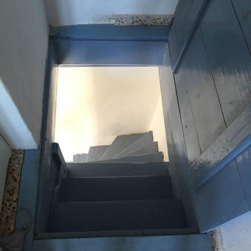 a set of stairs in a building with a window at School House with Panoramic View in Serifos Chora