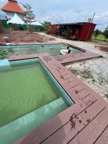 a pool of water with a person swimming in it at HOMESTAY Kampong KOTA AUR Resort with swimming pool, Kepala Batas, SEBERANG PERAI, PENANG -MOTAC registered Awarded ASEAN homestay standard Malaysia AWARD 2023-2025 Only 3 minutes from viral KG AGONG in Kepala Batas