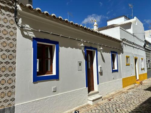 聖盧西亞的住宿－A Casinha，白色的建筑,在街上有蓝色的窗户