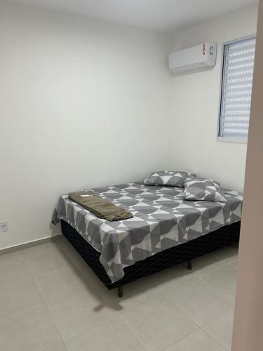 Cama en habitación blanca con marco de cama en Ap piscina Franca florenza, en Franca