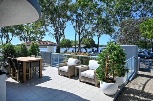 a patio with chairs and a table and a fence at Paradise at Picnic Point - 3B/R in Maroochydore