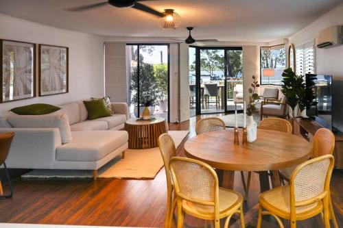 a living room with a couch and a table and chairs at Paradise at Picnic Point - 3B/R in Maroochydore
