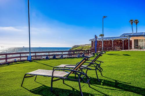 a group of benches sitting on the grass near the ocean at Casa 12 - Playa Arcangel in Rosarito