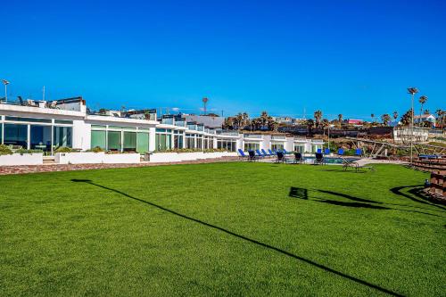 a large grassy field with a building in the background at Casa 12 - Playa Arcangel in Rosarito