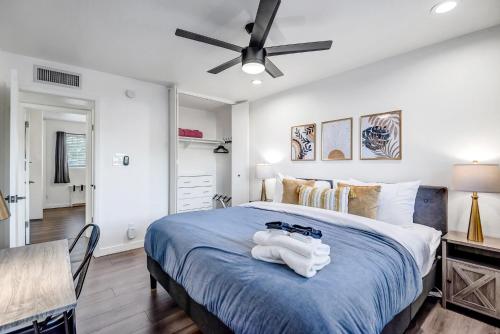 um quarto com uma cama azul e uma ventoinha de tecto em Scottsdale Desert Oasis- Resort Style Backyard w Private Pool and Nearby Shopping & Dining! em Scottsdale