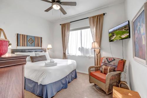 - une chambre avec un lit, une chaise et une télévision dans l'établissement Scottsdale Grayhawk Enclosed Sunroom, Outside Relaxing, Pool, Near 10 and Golf Courses & Concierge, à Scottsdale