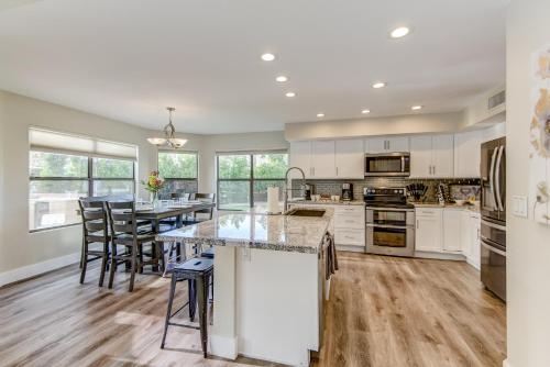 una cocina con armarios blancos y una gran isla en Scottsdale Desert Dream Estate Resort Style Lounging, Palm Trees, Pool & Hot Tub, Putting Green, en Phoenix