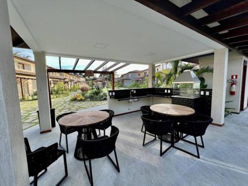 two tables and chairs on an outdoor patio at Village 115 Barra Grande (Viva Barra) in Marau