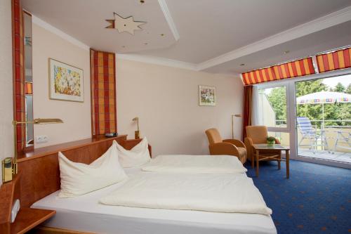 a hotel room with two beds and a balcony at Das Allgäu in Maierhöfen