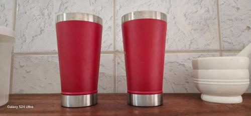 two red and silver tubes sitting on a table at Casa temporada Guriri in São Mateus