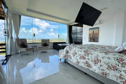 um quarto com uma cama grande e uma janela grande em 6 Suites, banheira, Piscina, no coração da Região dos Lagos em São Pedro da Aldeia