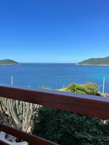 a view of the ocean from a wooden fence at Loft Pelicano Prainhas- Pontal do Atalaia- Para Casal - com Hidro in Arraial do Cabo