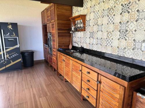 une cuisine avec des armoires en bois et un comptoir dans l'établissement 6 Suites, banheira, Piscina, no coração da Região dos Lagos, à São Pedro da Aldeia