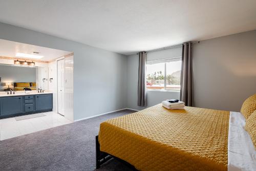 a bedroom with a large yellow bed and a kitchen at Scottsdale Old Town Haven, Walk To Old Town & Fashion Square Mall, Pool & Concierge Service! in Scottsdale