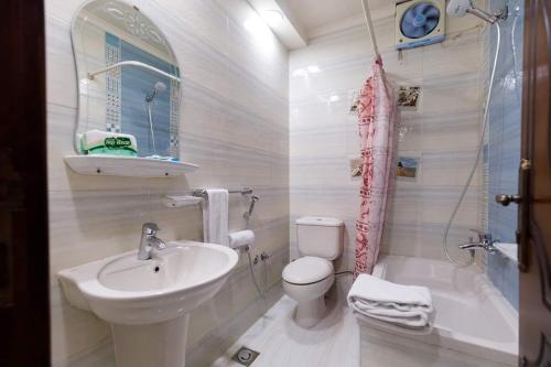a white bathroom with a sink and a toilet at Badr Hotel Assiut in Asyut