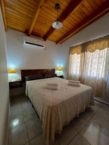 een slaapkamer met een bed met twee handdoeken erop bij Hospedaje Arroyito in Jardín América
