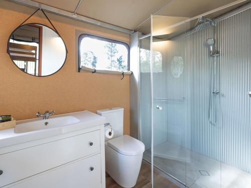 uma casa de banho com um chuveiro, um WC e um lavatório. em Paradise Country Farmstay em Gold Coast