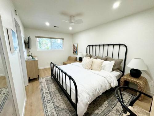 a bedroom with a large white bed and a window at SummerLillie #1 in Summerland