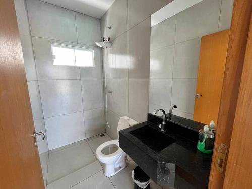 uma casa de banho com um lavatório e um WC em Chácara Espanha em Maringá