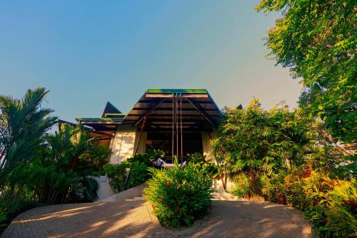 a house in the middle of a garden with trees at Hotel Three Sixty - Adults Only in Ojochal