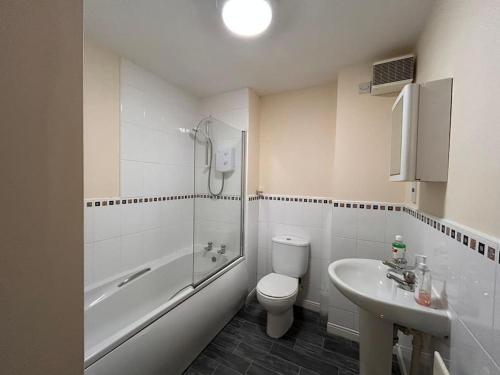 Baño blanco con aseo y lavamanos en Vyna Place-Close to City Hospital, en Nottingham