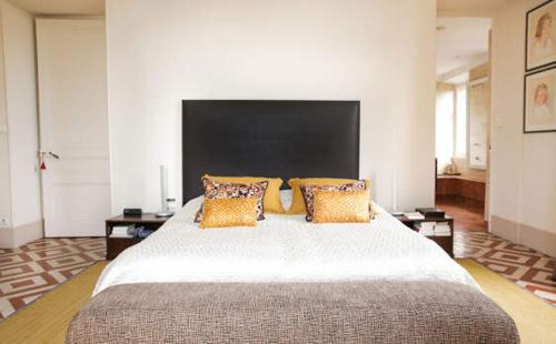 a large bedroom with a large bed with orange pillows at Villa Persienne in Cannes