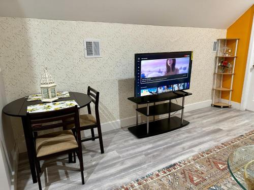 un salon avec une table et une télévision dans l'établissement Skylife Home away from home, à Irvington
