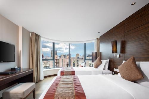 a hotel room with two beds and a large window at Newyantai Hotel Hainan in Haikou