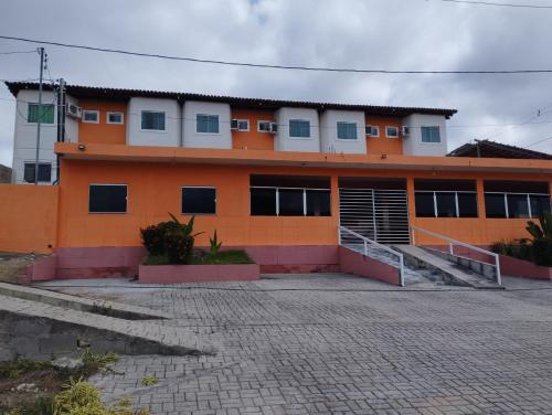 São João GrandeにあるPousada Flóridaの窓が多いオレンジと白の建物