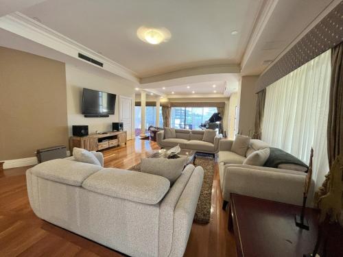 una gran sala de estar con sofás y TV. en 59 Lakeside Luxury Views 2br 2baparking en Perth