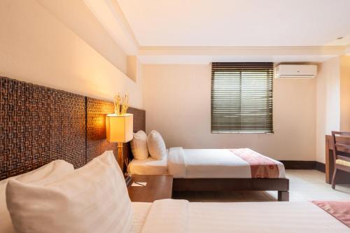 a hotel room with two beds and a couch at Le Soleil de Boracay Hotel in Boracay