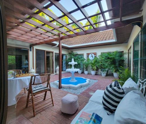 un patio con una fuente, una mesa y sillas en Vive Utila - Bed & Breakfast en Utila