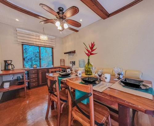 una cucina con tavolo, sedie e ventilatore a soffitto di Vive Utila - Bed & Breakfast a Útila