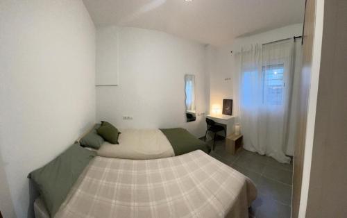 a small bedroom with a bed and a window at Casa Pancho.Casita acogedora en Valencia in Valencia