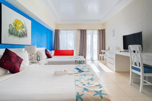 a hotel room with two beds and a desk at Le Soleil de Boracay Hotel in Boracay