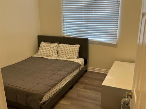 - un petit lit dans une chambre avec fenêtre dans l'établissement 2bedroom & 1bath home near Universal Studio & Hollywood, à Van Nuys
