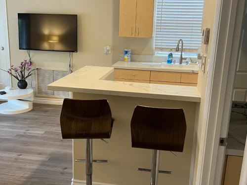 a kitchen with two bar stools and a sink at 2bedroom & 1bath home near Universal Studio & Hollywood in Van Nuys