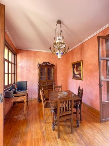 a dining room with a wooden table and chairs at NASS Casa del Aguila in Cuenca