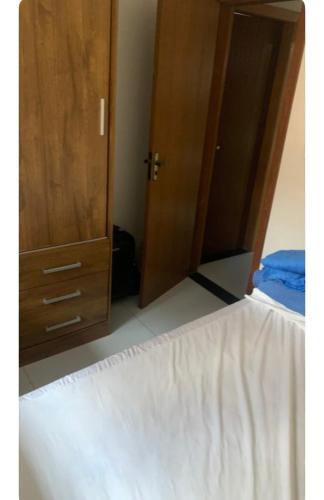 1 dormitorio con 1 cama y armario de madera en TALLYS, en Belo Horizonte