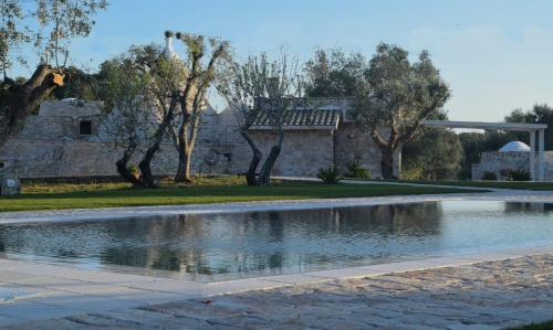 una piscina d'acqua in mezzo a un parco di Dimore Storiche - Ulivo di Aldo a Martina Franca
