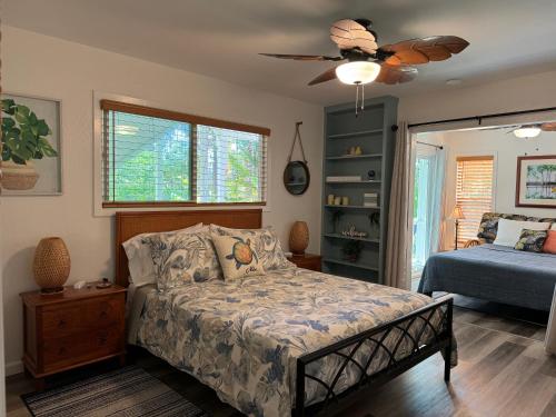 a bedroom with a bed and a ceiling fan at Hale O Malu at Kaloli Point in Keaau