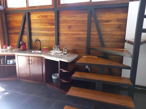 a kitchen with wooden walls and a sink and benches at Arenal Getaway in Fortuna