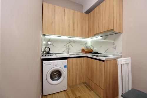 a kitchen with a washing machine and a sink at Mezani Guest House in Vlorë