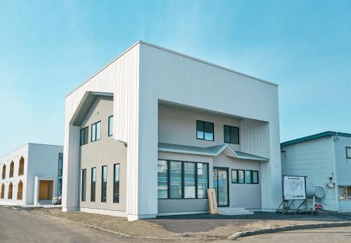 a white building with a sign in front of it at NEW HUMBER in Yubetsu
