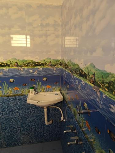a bathroom with a sink and a mural of a river at Thirunallar Heaven Homes in Thirunallar