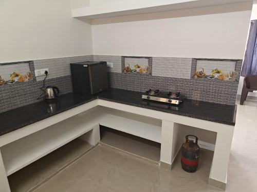 a kitchen with a counter with a microwave on it at Thirunallar Heaven Homes in Tirunallār