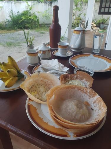 a table with plates of bread and bananas on it at Kabalana Ocean Blue in Ahangama