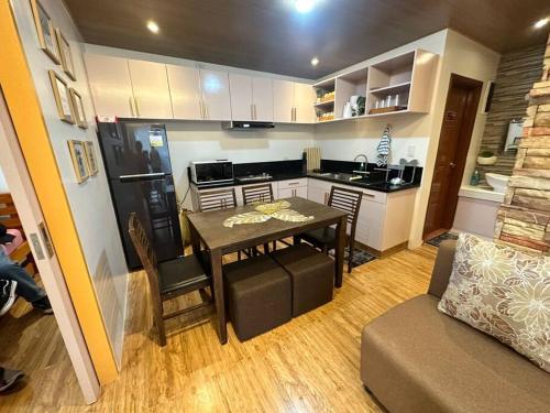 a small kitchen with a table and a couch at Yllib Transient Condo in Baguio